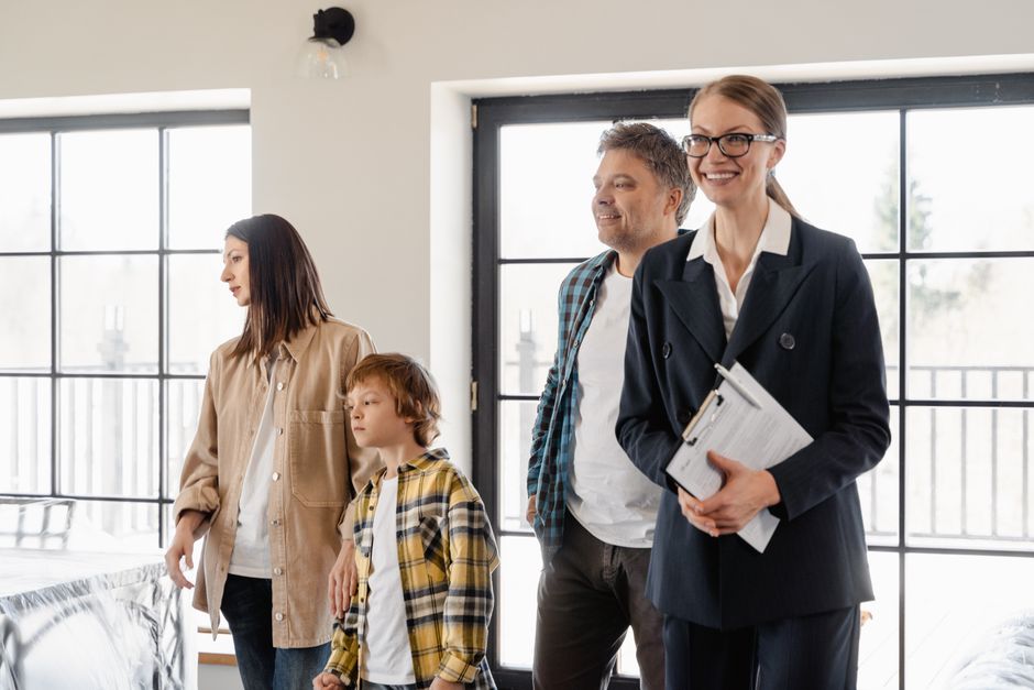 A family explores their new home with the help of a realtor, filled with excitement and anticipation.